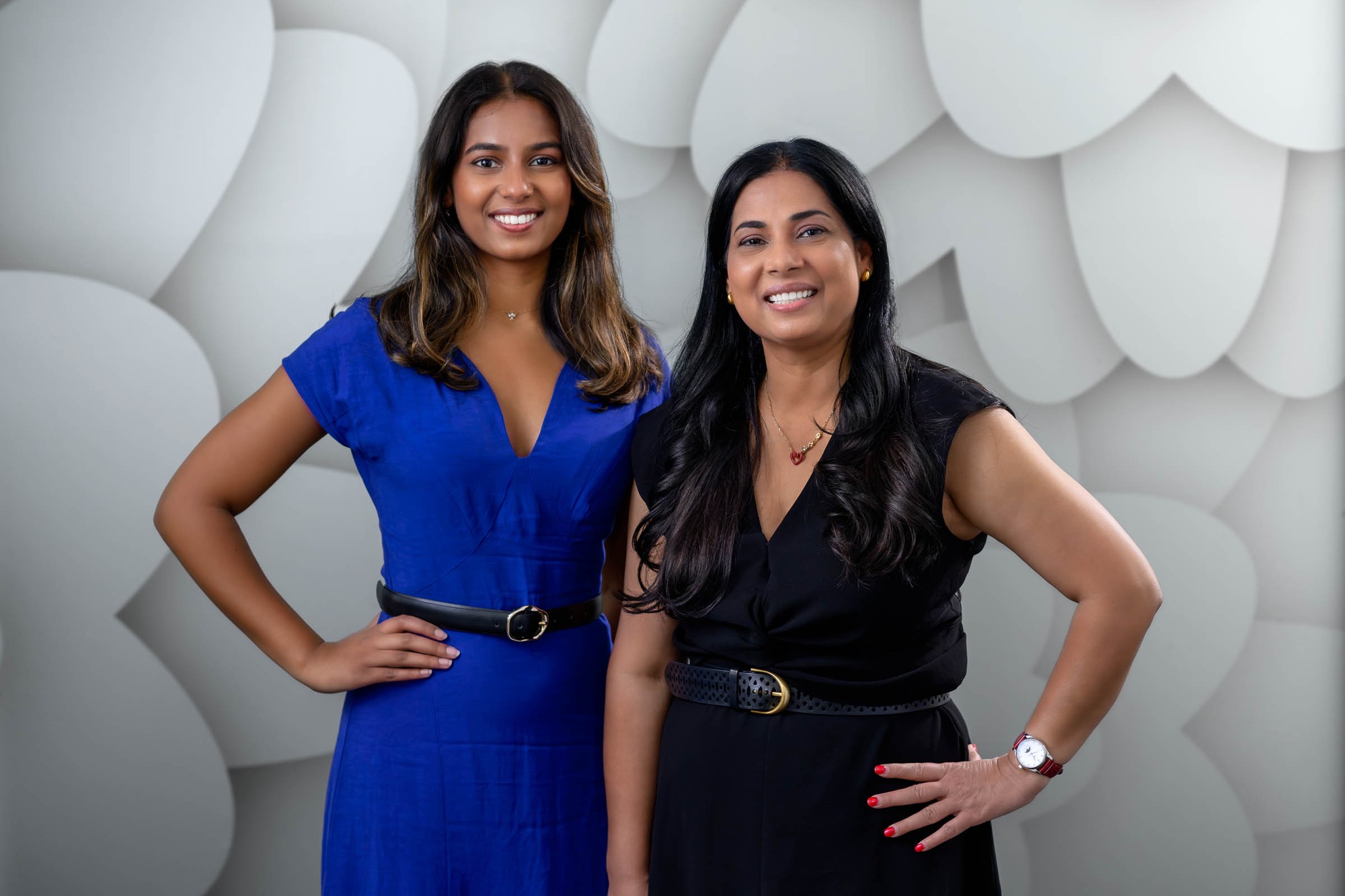 Dr Shania Paranavithana and Dr Renu Karn standing together in front of the Dental Excellence flower wall
